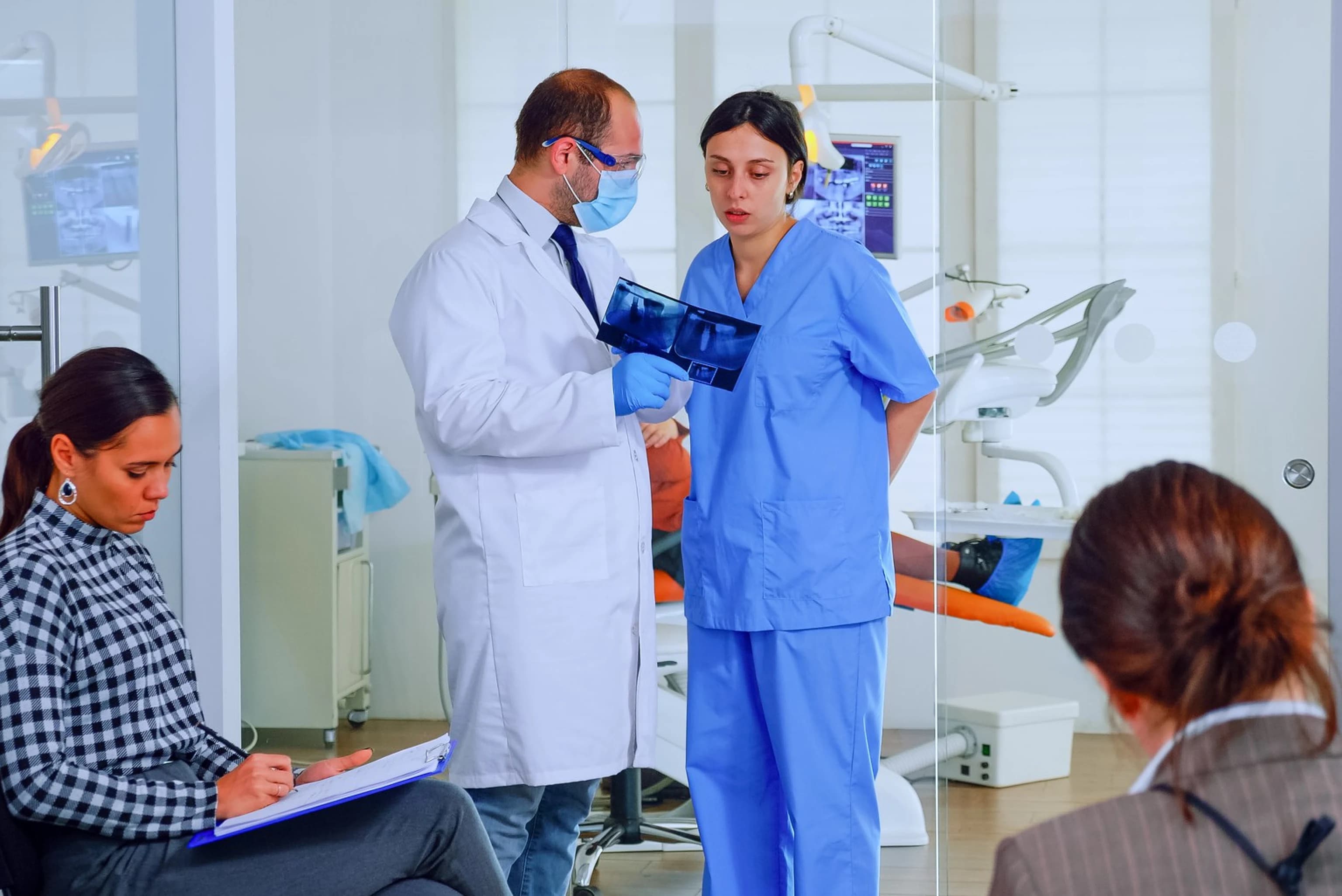 Doctor and nurse reviewing a patient X-ray together in a busy clinic